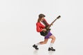 Stylish girl, retro musician wearing vintage style bright clothes playing guitar like rockstar  on white Royalty Free Stock Photo