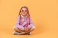 Stylish girl in rounded glasses with pink dreadlocks sitting, lo Royalty Free Stock Photo