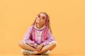 Stylish girl in rounded glasses with pink dreadlocks sitting, lo Royalty Free Stock Photo