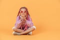 Stylish girl in rounded glasses with pink dreadlocks sitting, lo Royalty Free Stock Photo