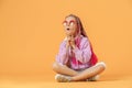 Stylish girl in rounded glasses with pink dreadlocks sitting, th Royalty Free Stock Photo