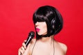 Stylish girl singing with a microphone, red Royalty Free Stock Photo