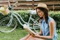 Stylish girl in straw hat reading Royalty Free Stock Photo