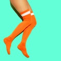 Stylish girl in vintage orange stockings on blue fresh minimal background. Sport fitness summer active vibes