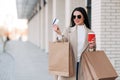 Stylish girl walking with coffee and shopping bags and doing shopping Royalty Free Stock Photo