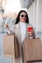 Stylish girl walking with coffee and shopping bags and doing shopping Royalty Free Stock Photo