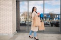 girl  walking with coffee and shopping eco bags after doing shopping. Royalty Free Stock Photo