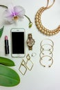 Stylish girly set of accessories watch necklace earrings bracelets lipstick with orchid on a white background