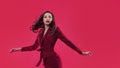 Stylish glamorous girl. Attractive young brunette dressed in fuchsia color, fuchsia color background.