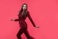 Stylish glamorous girl. Attractive young brunette dressed in fuchsia color, fuchsia color background.