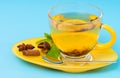 Stylish glass cup and yellow saucer with lemon tea