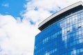 Stylish Glass Facade of blue Tinted Semi-Transparent Glass Building Against Blue Sky with Sunbeams.