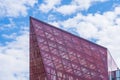 Stylish Glass Facade of Violet Tinted Semi-Transparent Glass Building Against Blue Sky with Sunbeams