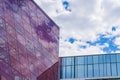 Stylish Glass Facade of Violet Tinted Semi-Transparent Glass Building Against Blue Sky with Sunbeams