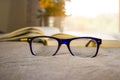 Stylish glasses closeup and blured book.