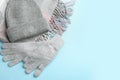 Stylish gloves, scarf and hat on light blue background, flat lay. Space for text Royalty Free Stock Photo