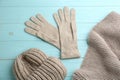 Stylish gloves, scarf and hat on light blue wooden background, flat lay Royalty Free Stock Photo