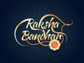 Stylish golden Raksha Bandhan text with beautiful rakhi.