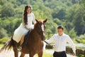 Stylish gorgeous happy brunette bride riding a horse and elegant