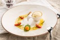 Stylish gourmet dessert with vanilla ice cream and fruit served on white plate at restaurant Royalty Free Stock Photo