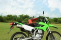 Stylish green cross motorcycle with helmet outdoors Royalty Free Stock Photo