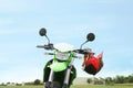 Stylish green cross motorcycle with helmet outdoors Royalty Free Stock Photo