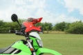 Stylish green cross motorcycle with helmet outdoors, space for text Royalty Free Stock Photo