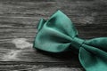 Stylish green satin bow tie on black wooden background, closeup Royalty Free Stock Photo