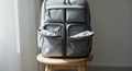 Modern Grey Backpack with Multiple Pockets Sitting on a Wooden Stool Royalty Free Stock Photo
