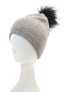 Stylish grey hat with pompom on a mannequin. Isolated on white background