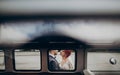 Stylish groom and happy bride embracing and gently kissing at retro car. emotional romantic moment, space for text. unusual view Royalty Free Stock Photo