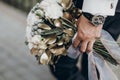 Stylish groom holding amazing bouquet of roses and golden leaves Royalty Free Stock Photo