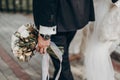 Stylish groom holding amazing bouquet of roses and golden leaves Royalty Free Stock Photo