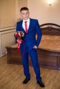 Stylish groom holds wedding bouquet. Young groom in a suit. Groom in classic clothes with bow tie Royalty Free Stock Photo