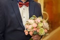 Stylish groom holds wedding bouquet. Young groom in a suit. Royalty Free Stock Photo