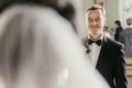 Stylish groom looking at his gorgeous bride in stylish dress with amazing bouquet posing in luxury room in hotel. beautiful woman Royalty Free Stock Photo