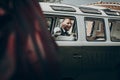 Stylish groom in retro car smiling, sitting inside with bouquet and waiting for bride in the morning for wedding ceremony. luxury Royalty Free Stock Photo