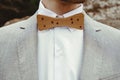 Stylish groom`s wooden bow tie, close up on background rocks at Royalty Free Stock Photo