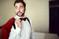 Stylish groom in tuxedo suit marsala red, burgundy bow tie, professional hairstyle, beard, mustache. Wedding Royalty Free Stock Photo