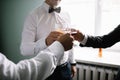 Stylish groomsmen helping happy groom getting ready in the morning Royalty Free Stock Photo