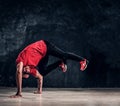 Stylish guy performs breakdance acrobatic elements.