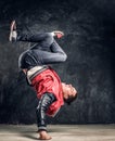 Stylish guy performs breakdance acrobatic elements.