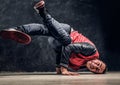 Stylish guy performs breakdance acrobatic elements.