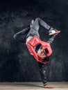 Stylish guy performs breakdance acrobatic elements.