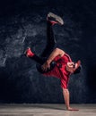 Stylish guy performs breakdance acrobatic elements.