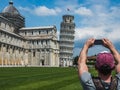 Stylish guy with a phone taking pictures of the Leaning Tower Royalty Free Stock Photo