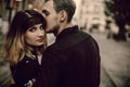 stylish gypsy couple in love kissing hugging in evening city street. woman and man gently embracing, romantic french atmospheric Royalty Free Stock Photo