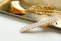 Stylish hair clips and gold tray on white table Royalty Free Stock Photo