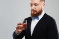 Stylish handsome bearded man enjoying a brandy or whiskey