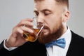 Stylish handsome bearded man enjoying a brandy or whiskey